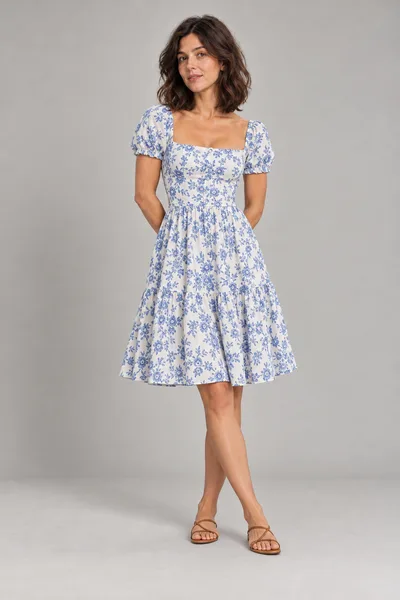 Mulher de vestido floral azul e branco na altura do joelho e sandálias caramelo — prévia do trocador de roupa com IA